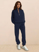 Woman wearing cotton-blended two-piece tracksuit with high collar and zipper, styled for casual athleisure look