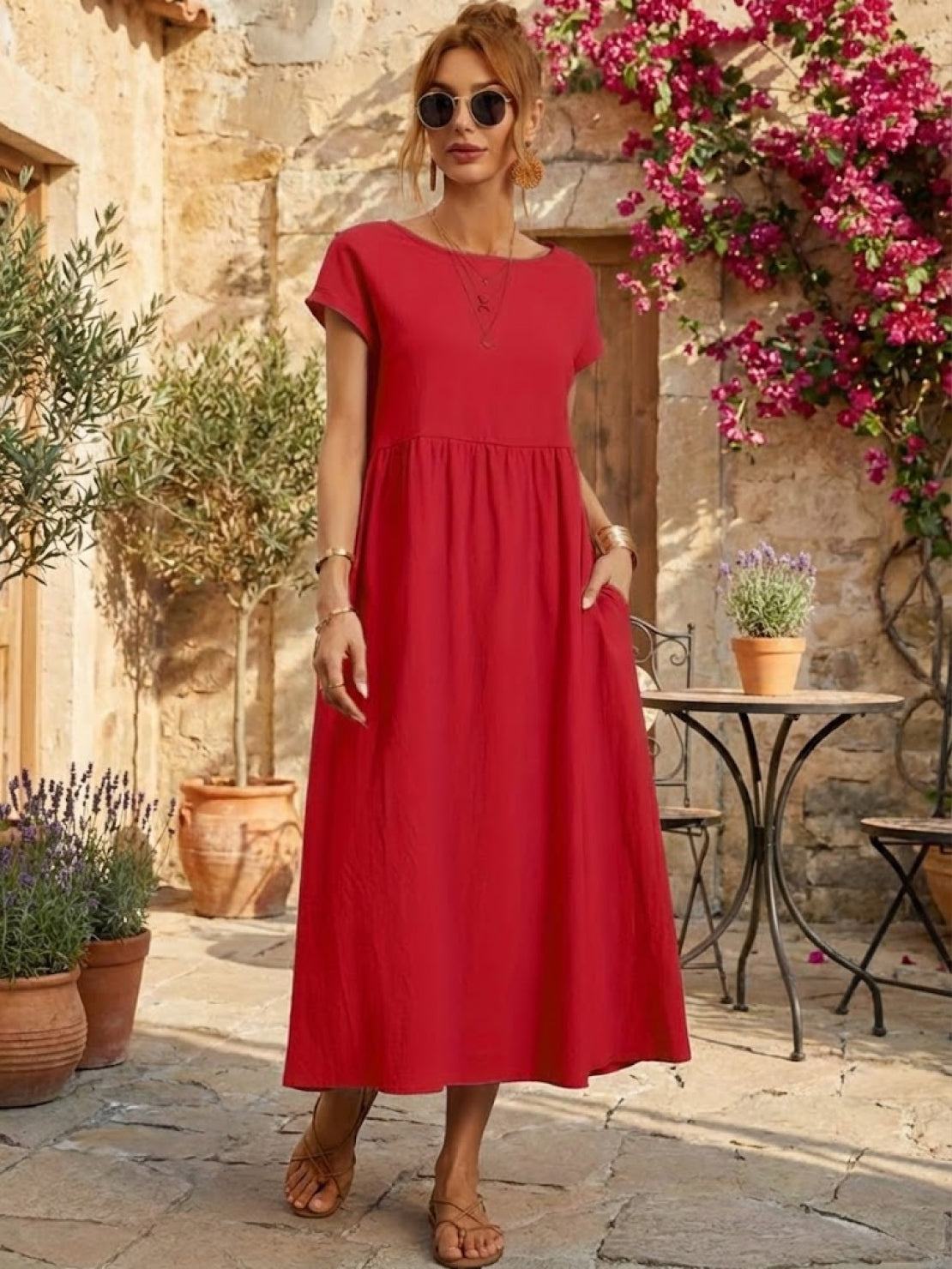 Woman wearing capped-sleeve voluminous pleated midi dress with flowing skirt and pockets