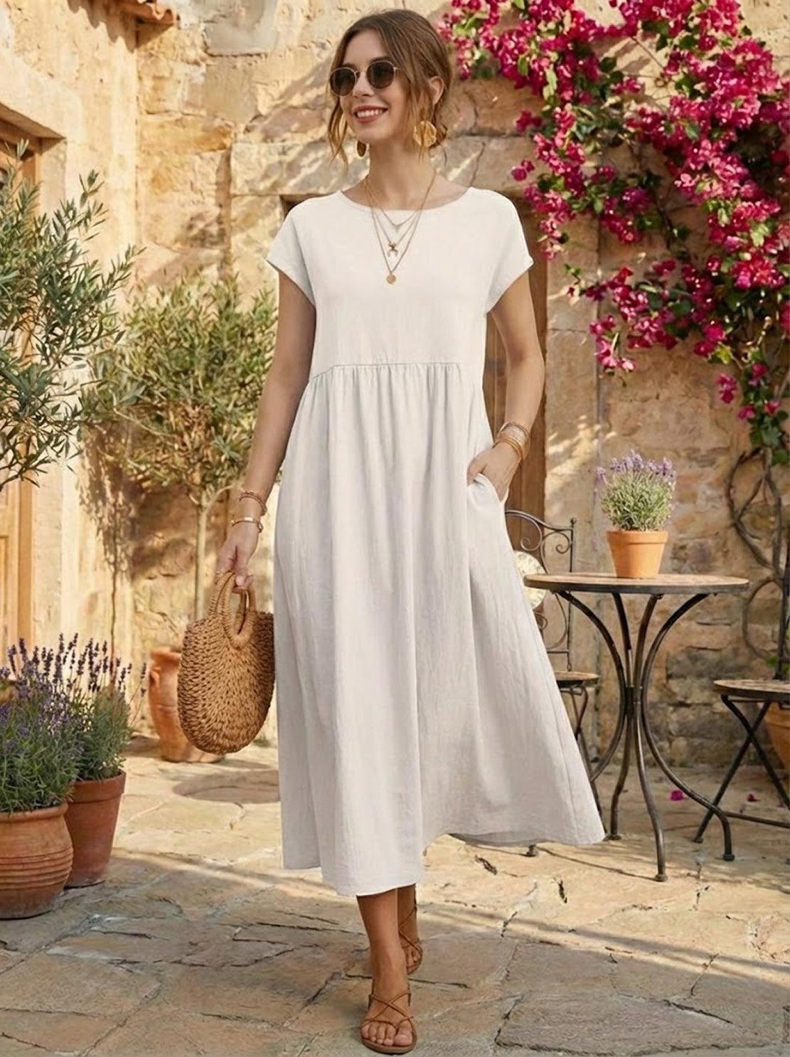 Woman wearing a capped-sleeve voluminous pleated midi dress with flowing skirt and pockets