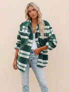 Woman wearing green and white comfy flannel classic button-down shirt with light blue jeans