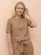 Woman wearing a relaxed cotton linen set with short-sleeve top and straight-leg pants in monochrome tones