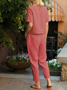 Woman wearing relaxed cotton linen set with short-sleeve top and straight-leg pants in monochrome tones