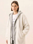 Woman wearing cozy white oversized sherpa long coat with hood and soft fabric, perfect everyday wear oversized coat for cold weather.