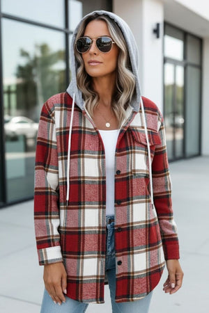 Woman wearing a Highland Plaid Shacket with red plaid pattern, soft fleece lining, and attached gray hood.