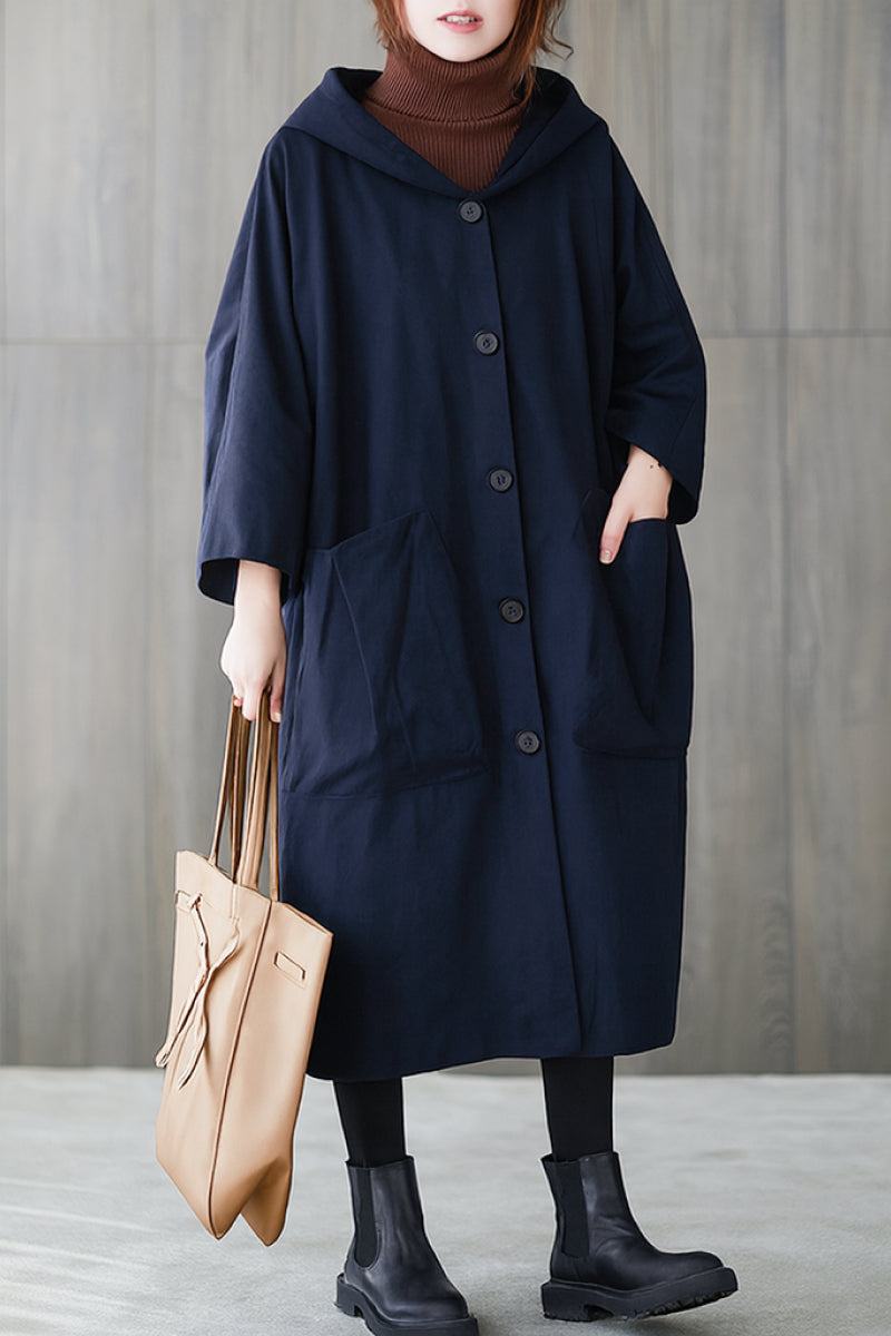 One-size oversized Heritage Windbreaker Jacket with hood and front pockets in navy blue worn with black leggings and ankle boots