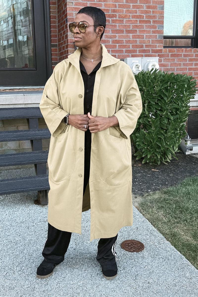One size fits all oversized beige windbreaker jacket with waterproof design, snap-button closure, attached hood, and large front pockets.