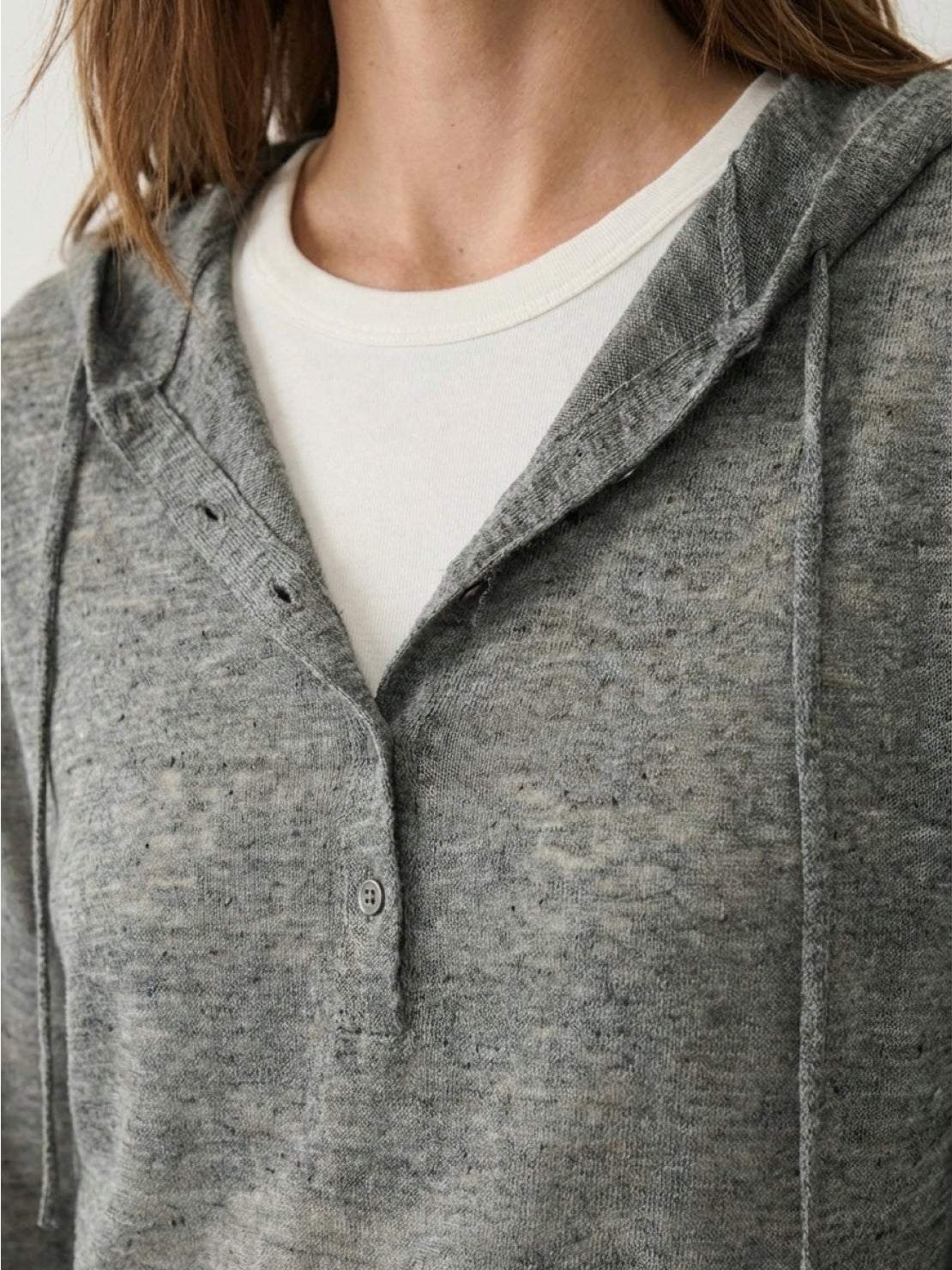 Organic linen henley top with fine knit, relaxed fit, long sleeves, side slits, and heathered texture.