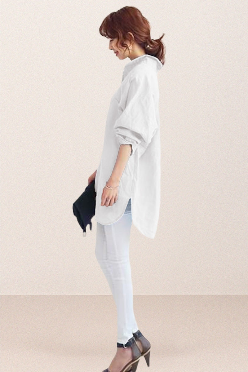 Woman wearing oversized white linen shirt with rolled sleeves and high-low hem