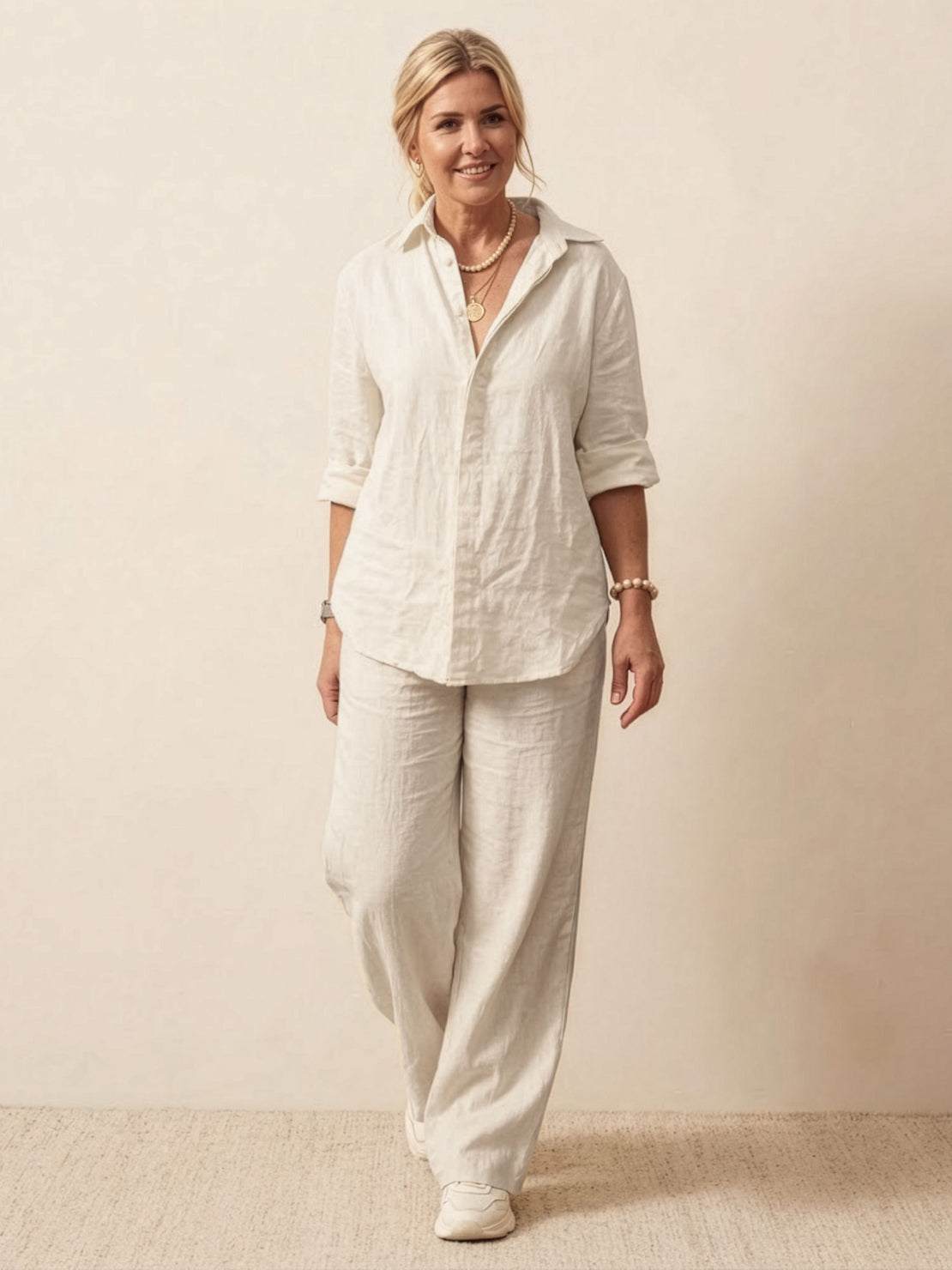 Woman wearing oversized 100% cotton shirt and wide-leg pants co-ord set in white, styled casually with rolled sleeves.