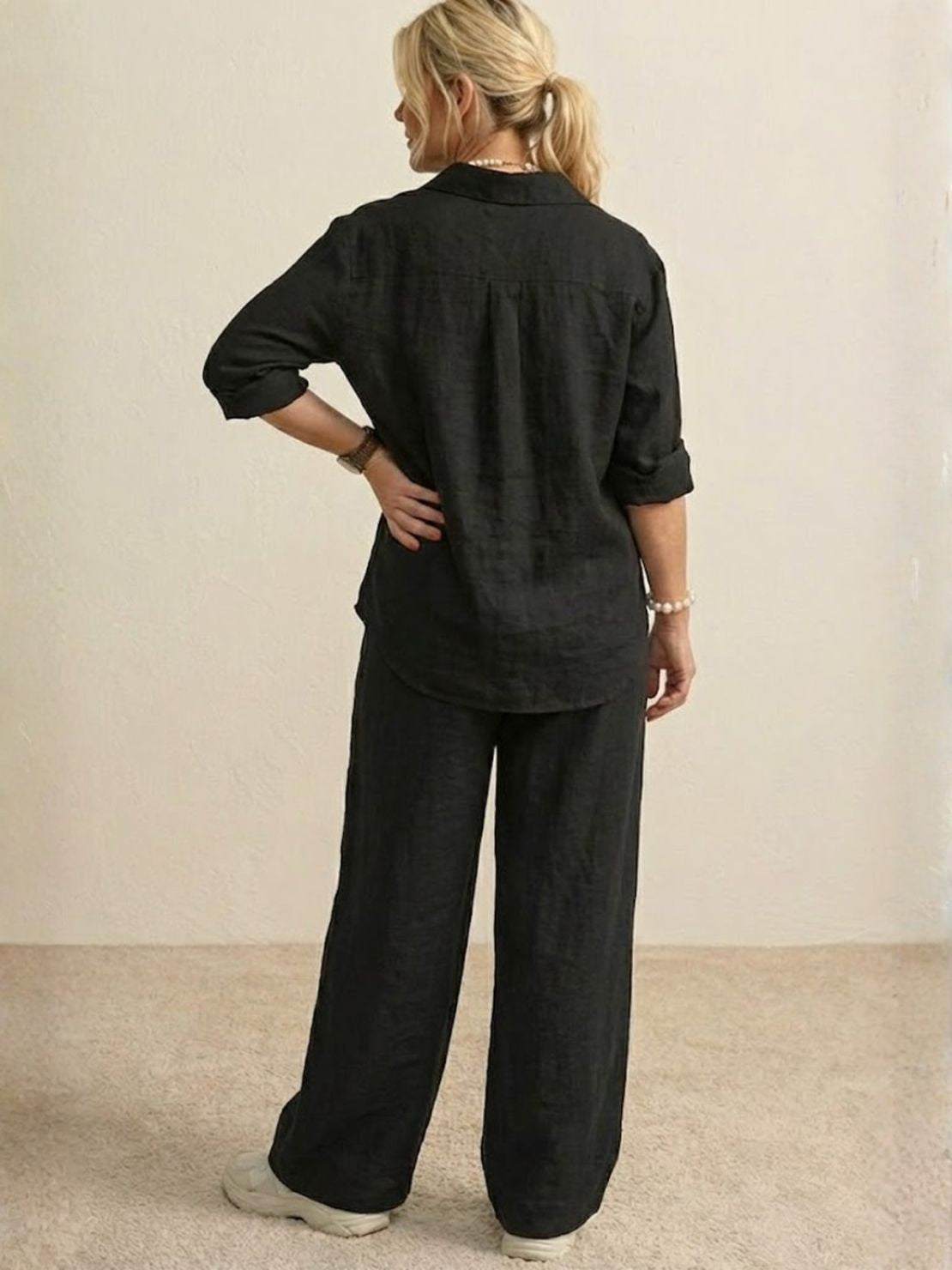Woman wearing oversized 100% cotton black shirt and wide-leg pants co-ord set, back view.