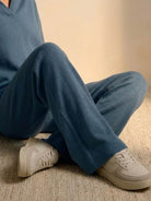 Cozy blue knitted two-piece lounge set with polo collar and wide-leg pants paired with beige sneakers.