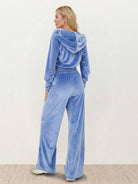Woman wearing a modern cropped velour tracksuit set with high-waist pants in vibrant color