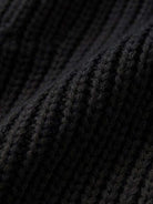 Close-up of black knit fabric texture for relaxed fit oversized cardigan