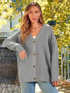 Relaxed fit oversized gray knit cardigan with buttons worn outdoors by woman