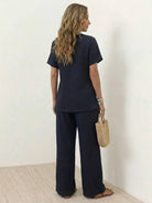 Woman wearing textured elegance two-piece set with asymmetrical top and wide-leg pants