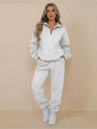 Woman wearing an ultra-soft and comfy co-ord tracksuit set in light gray with a zip-up top and jogger pants.