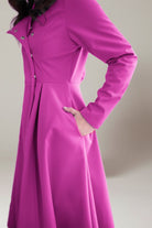 Water-repellent A-line hooded women's raincoat in vibrant pink with belt and flattering fit