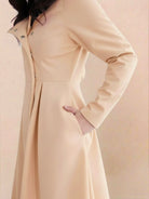 Water-repellent A-line hooded raincoat with belt, feminine fit, and insulated lining for warmth and style.